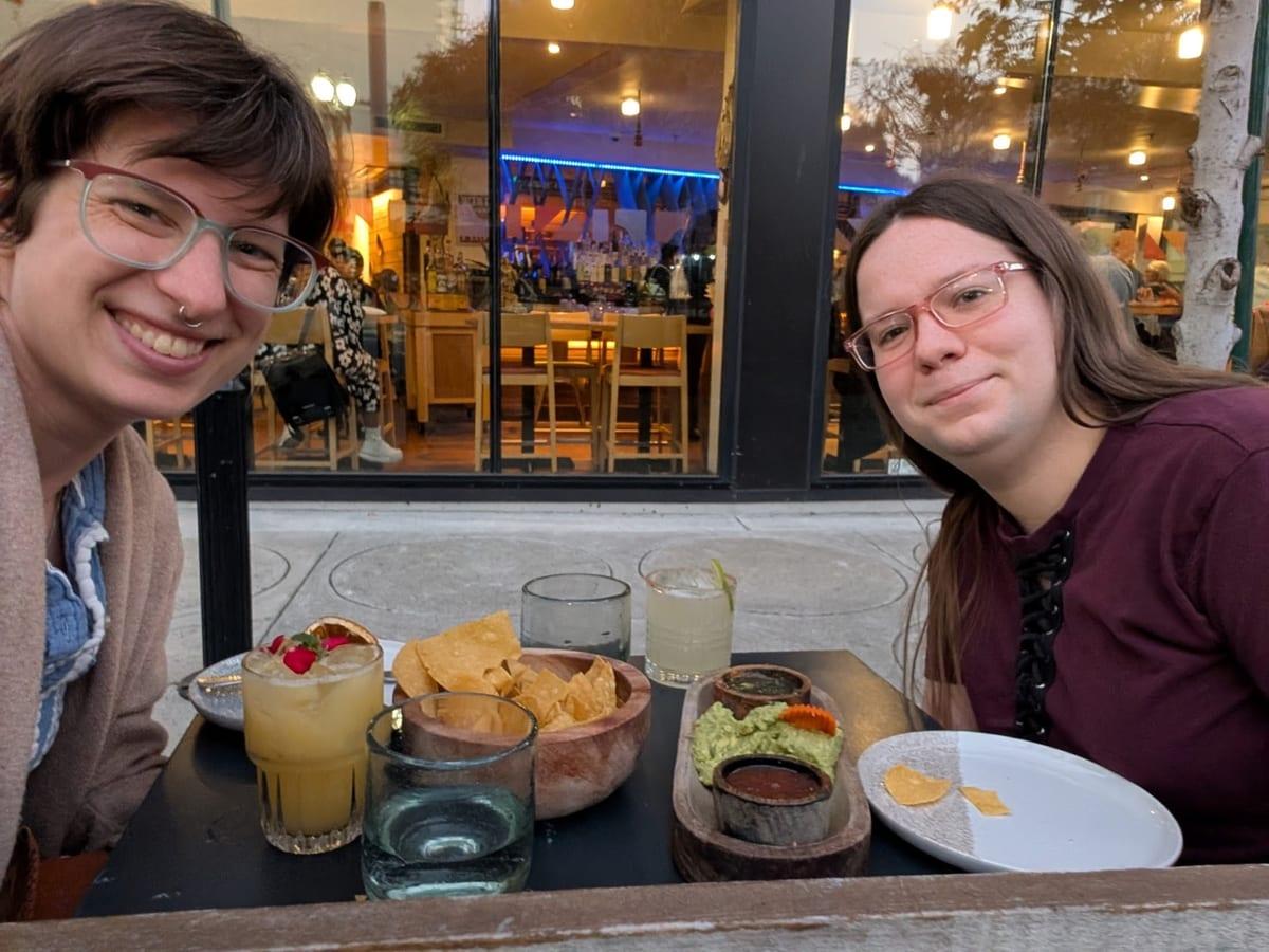 Pastor Remi and family smiling at a patio table with chips and drinks