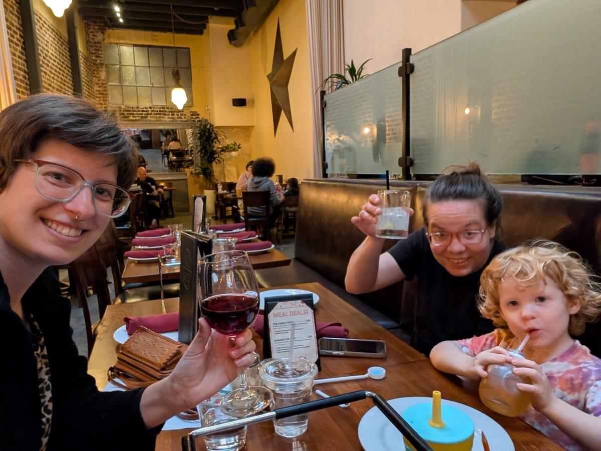 Pastor Remi raising a glass with family at a restaurant table