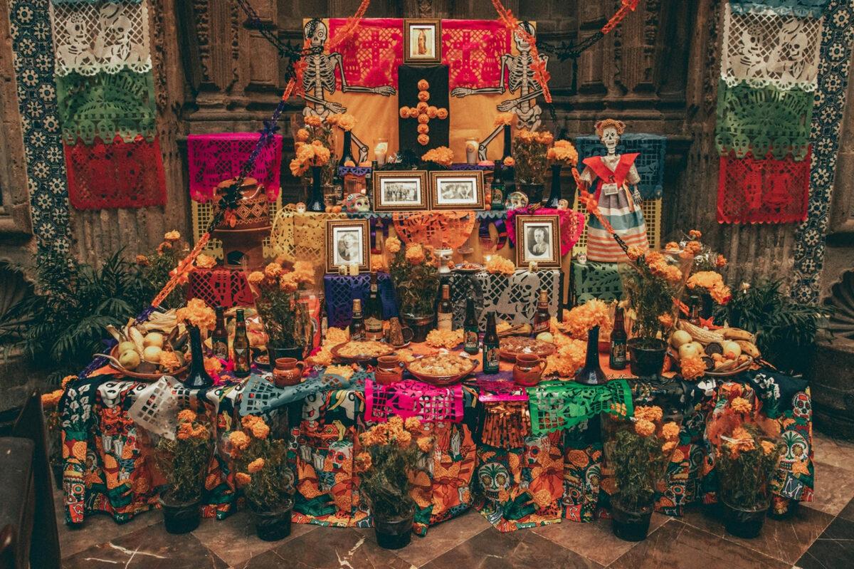 A colorful altar decorated with marigolds, papel picado, and photos of loved ones