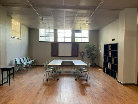 Board room table inside the area with a fireplace. It also has a whiteboard and a cubie wall.